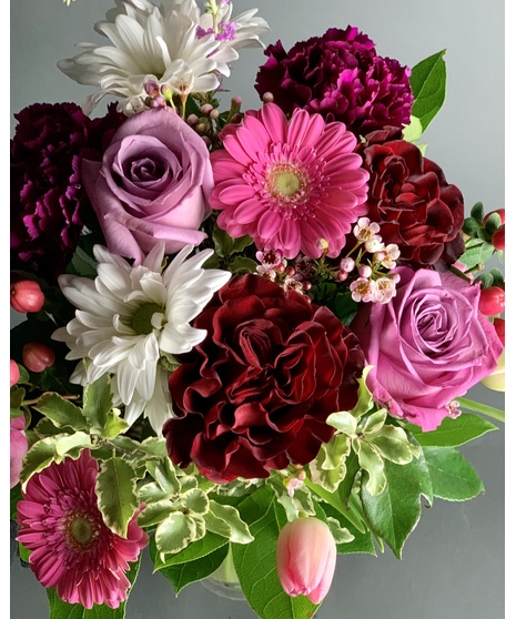 A floral arrangement featuring sunflowers and rainbow roses. The smaller size includes 3 sunflowers and 3 roses, while the larger size features 6 sunflowers and 6 roses. 