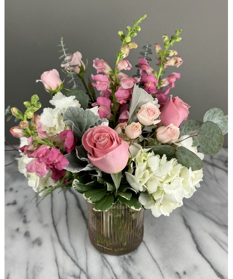 A floral arrangement featuring pink and white blooms, including blush roses, white lilies, and pink hydrangeas. Perfect for elegant and joyful celebrations.