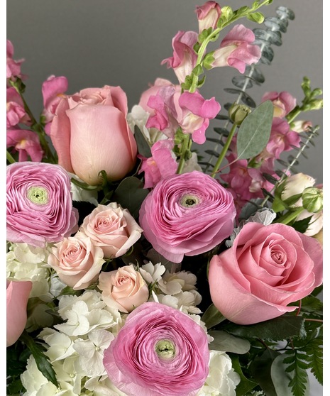 A floral arrangement featuring pink and white blooms, including blush roses, white lilies, and pink hydrangeas. Perfect for elegant and joyful celebrations.