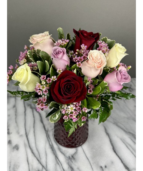 A bouquet of mixed-color roses featuring a variety of shades, including pinks, reds, and yellows. Colors may vary based on seasonal availability. Arranged for Valentine’s Day.