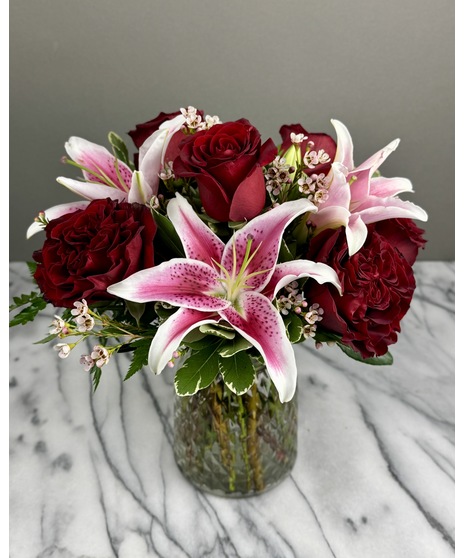 A floral arrangement featuring roses and lilies.