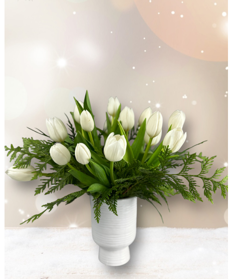 An arrangement of fresh white tulips and seasonal greenery in a white vase. Option to add gold accents for a festive touch.