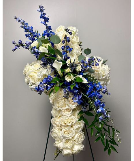 spray of blue flowers on white cross